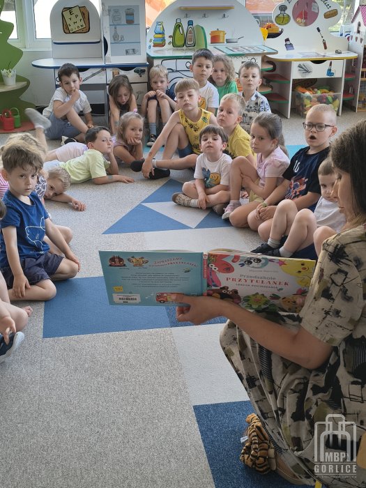 Biblioteka Gorlice, CPCD dzieci z zainteresowaniem słuchają treści czytanej książki.jpg